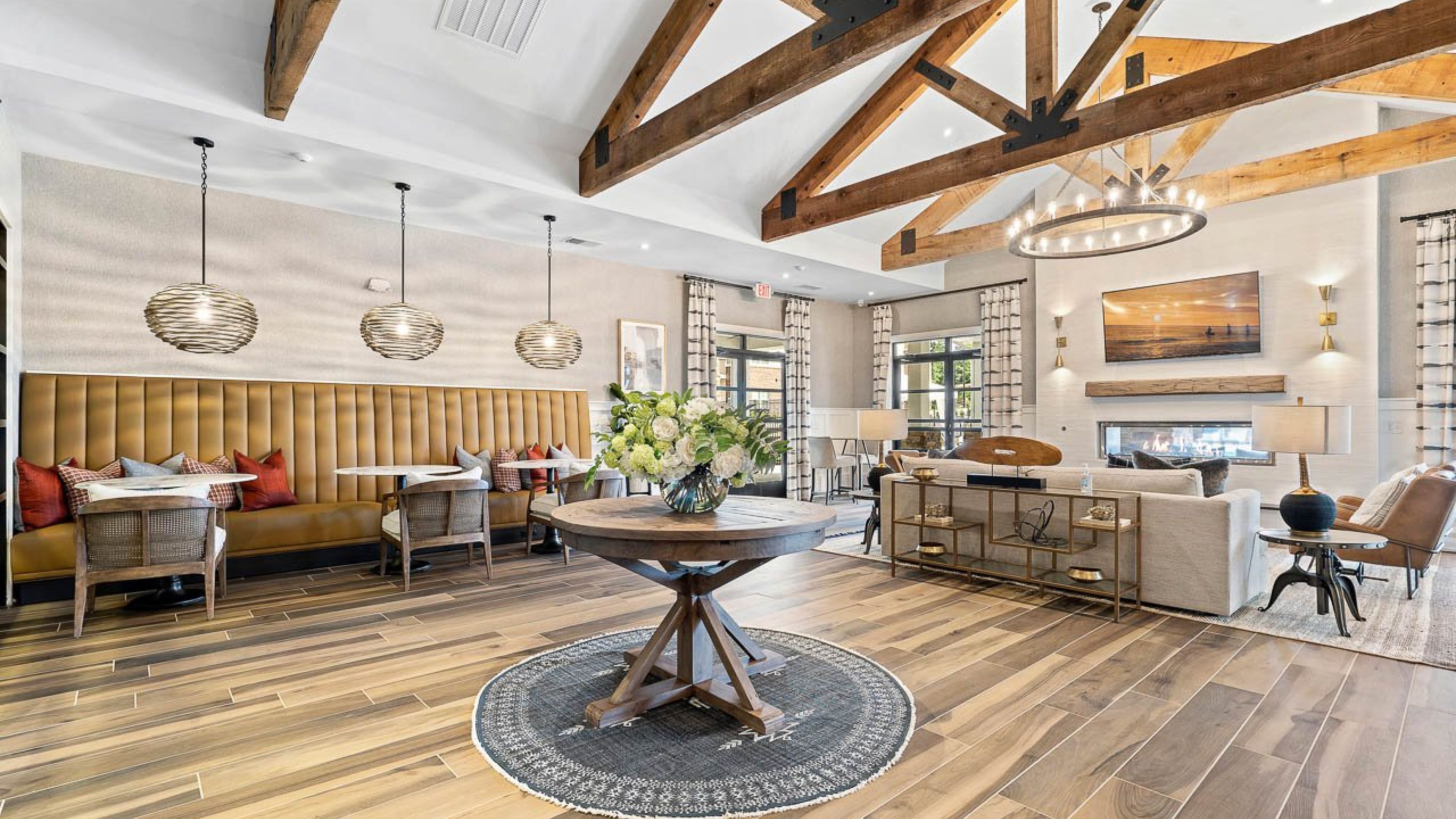 Hawthorne Waterstone resident club house with tables and booth seating and a fireplace with surrounding chairs and a couch